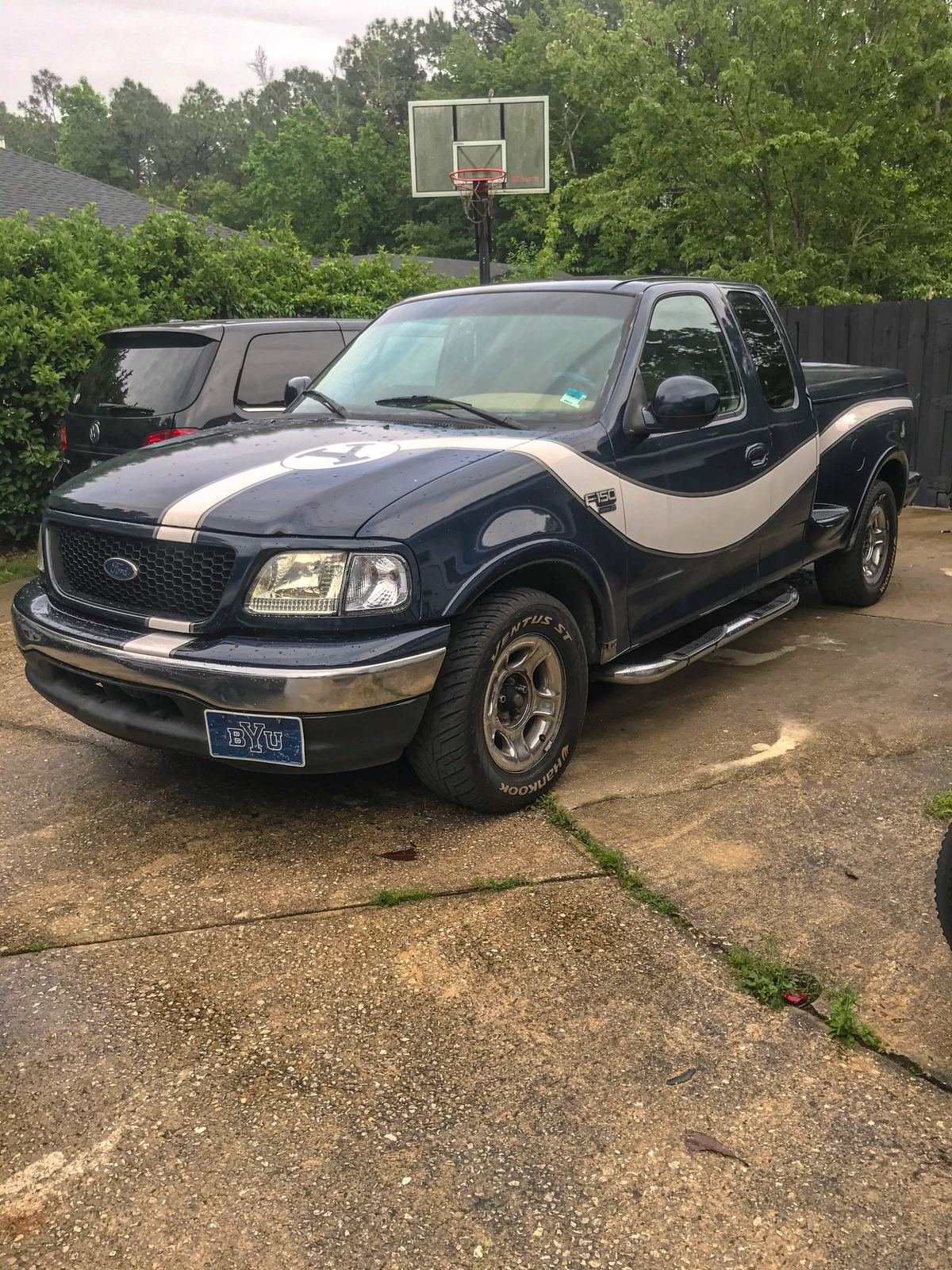 Emilio's first truck, a navy Ford F-150 with a silver stripe