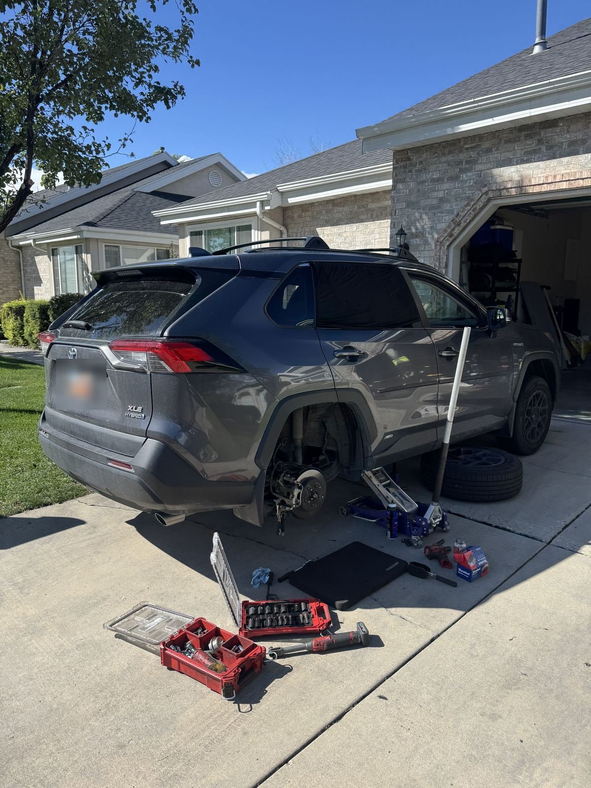 Toyota RAV4 with a rear wheel off in a home driveway