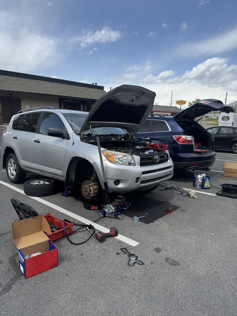 Toyota RAV4 with the hood up and a front wheel off