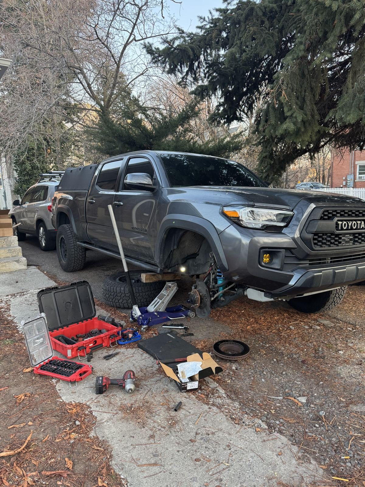 Toyota Tacoma with a front wheel off and tools laid out