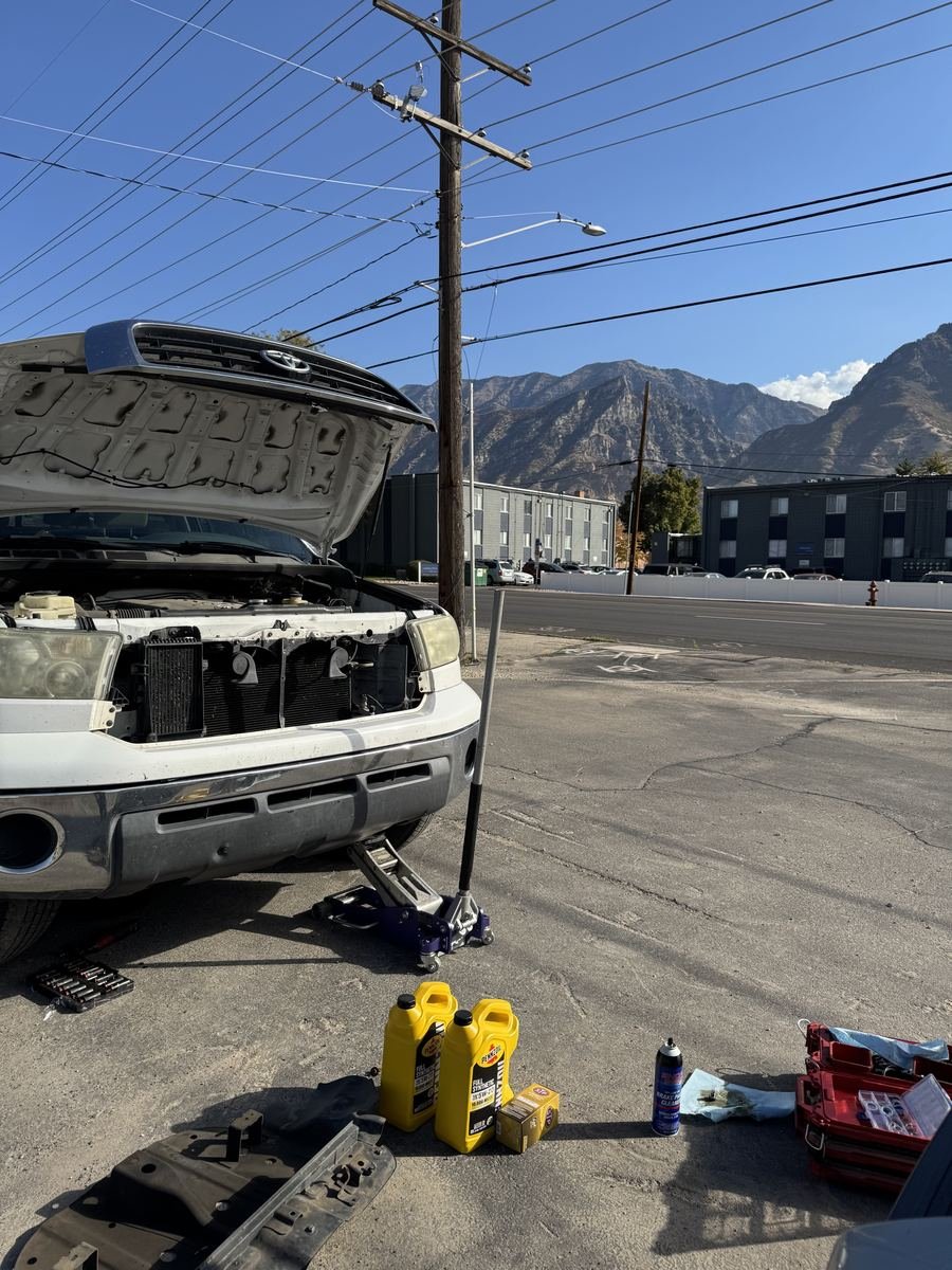 White Toyota Tundra on a jack with oil bottles beside it