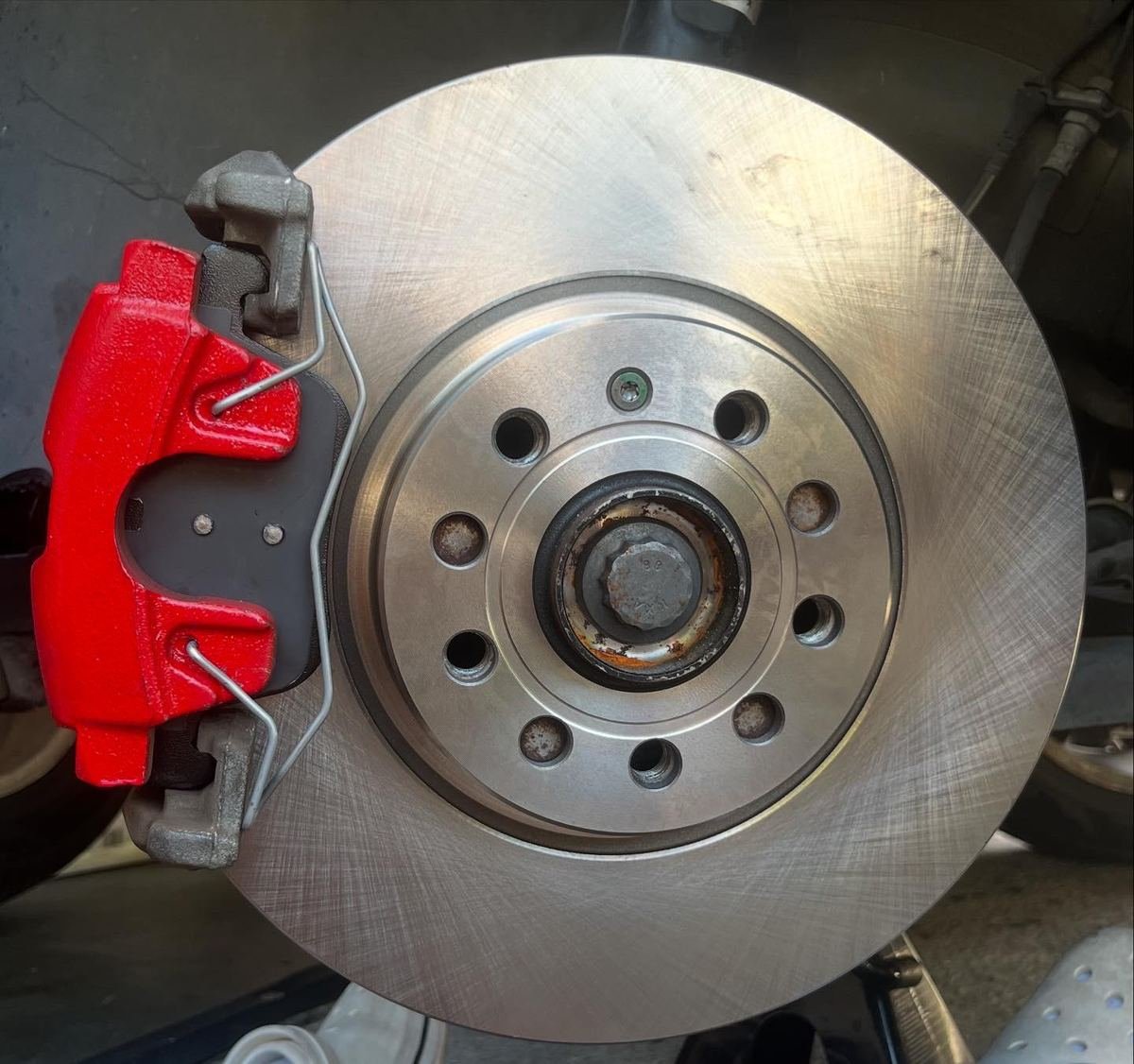 New rotor installed behind a red brake caliper