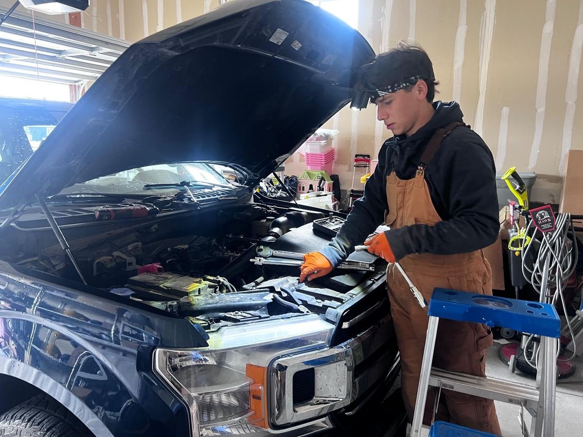 Emilio working under the hood of a pickup truck